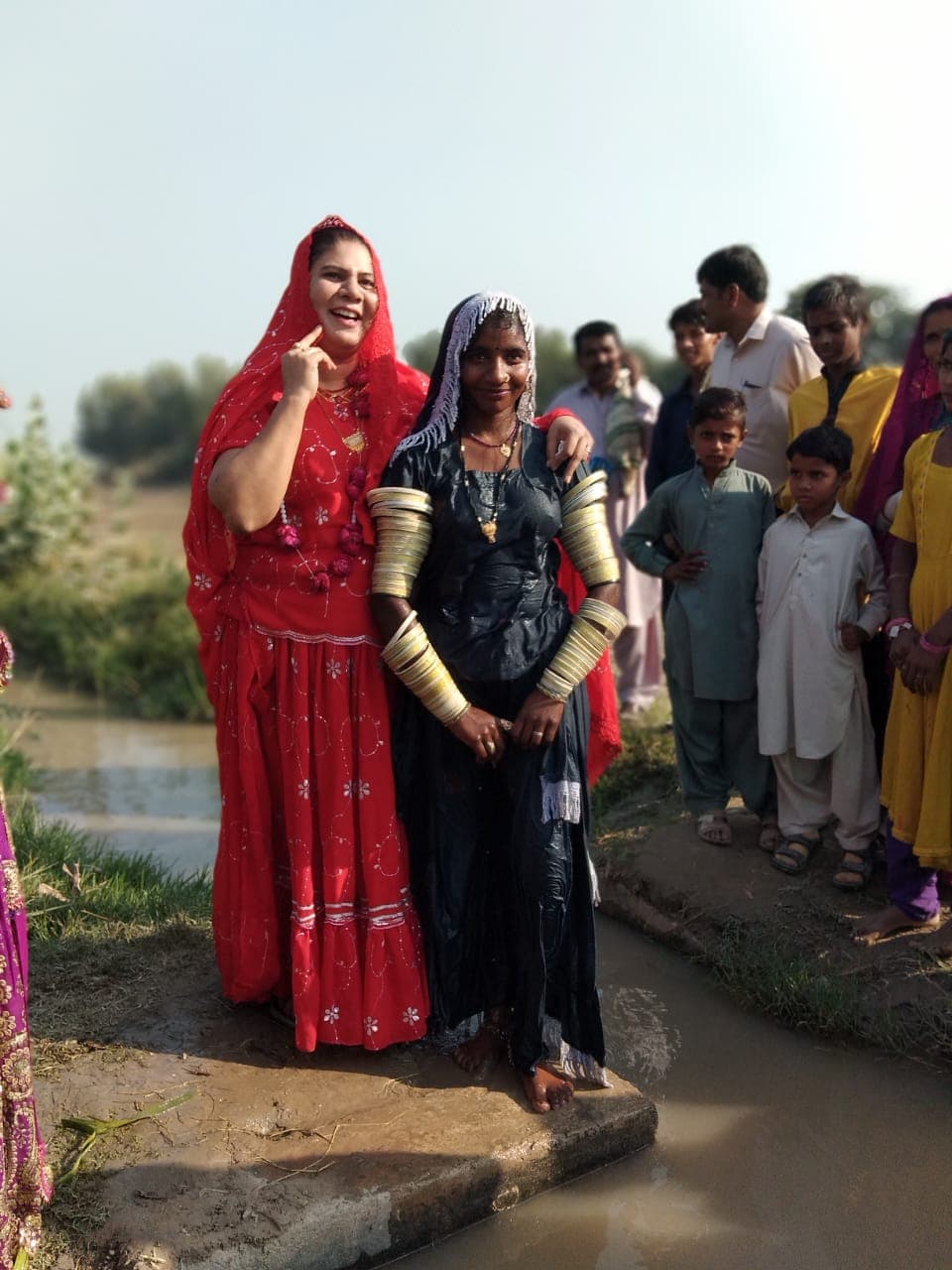 Ruby Naeem John standing with a Marwari woman near a canal