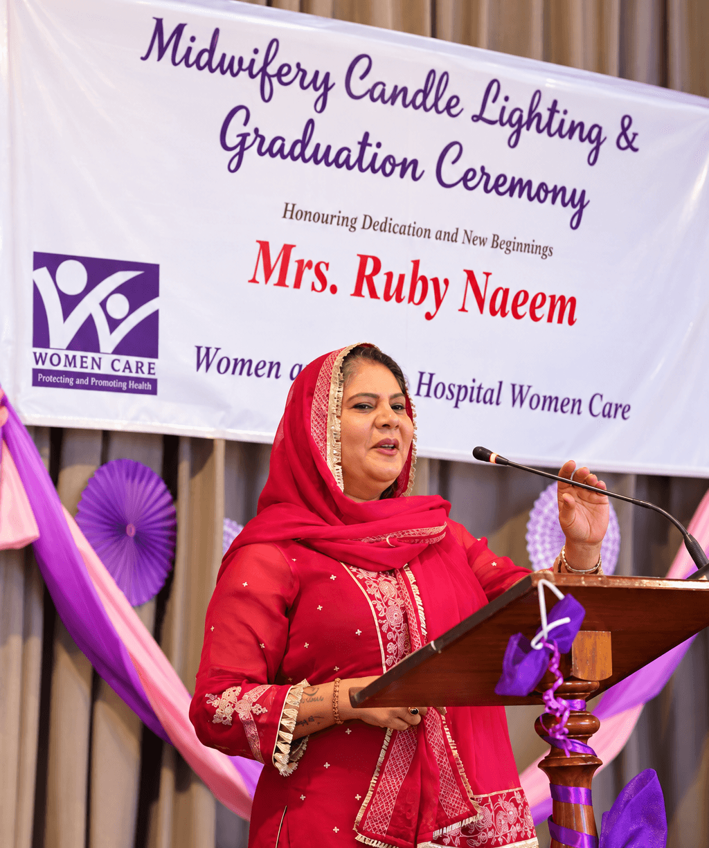 Ruby Naeem John speaking at a podium during a ministry event